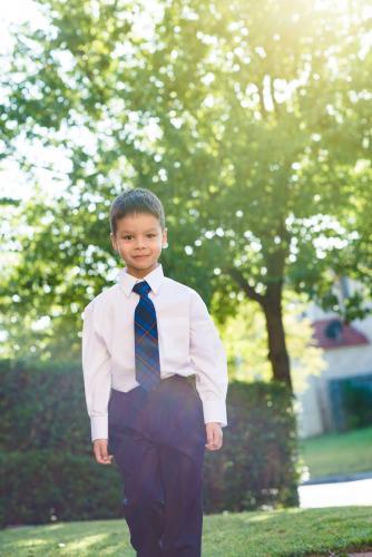5 year old mixed race boy wearing his school uniform on his first day of school - Australian Stock Image