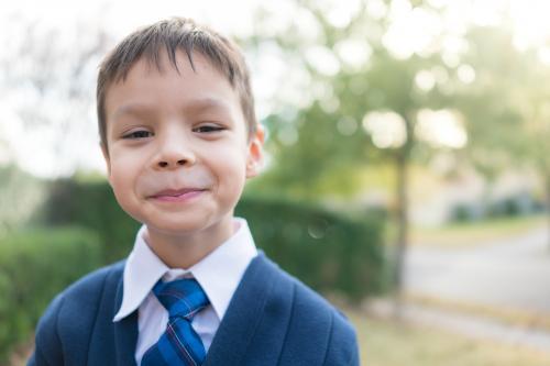 5 year old mixed race boy wearing his winter school uniform - Australian Stock Image