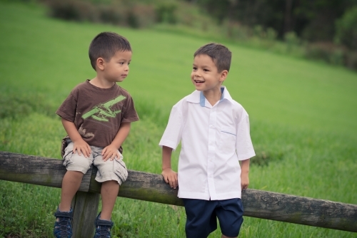 6 year old mixed race boy plays with his brother before leaving on his first day of school - Australian Stock Image