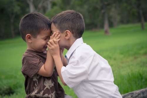 6 year old mixed race boy plays with his brother before leaving on his first day of school - Australian Stock Image