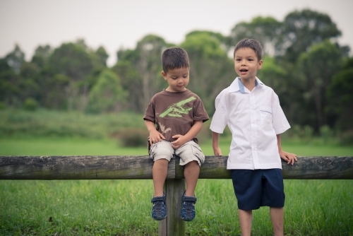 6 year old mixed race boy plays with his brother before leaving on his first day of school - Australian Stock Image