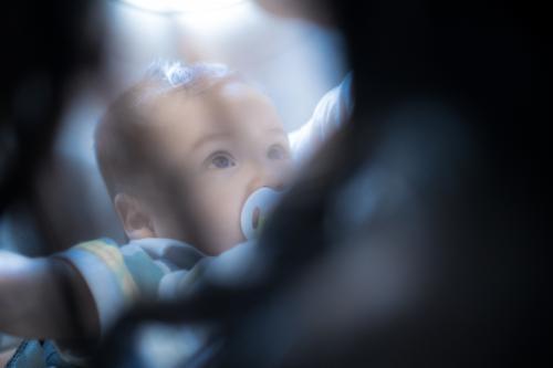 9 month old mixed race baby boy travels with his mother on a commercial aeroplane flight - Australian Stock Image