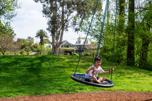 A boy enjoying a giant swing ride - Australian Stock Image