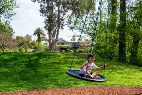 A boy enjoying a giant swing ride