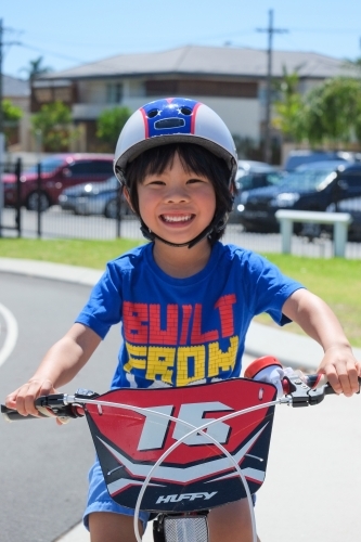 a boy happily riding his bike on a bike track - Australian Stock Image
