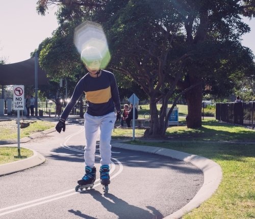 a boy inline skating at the park with rollerblades