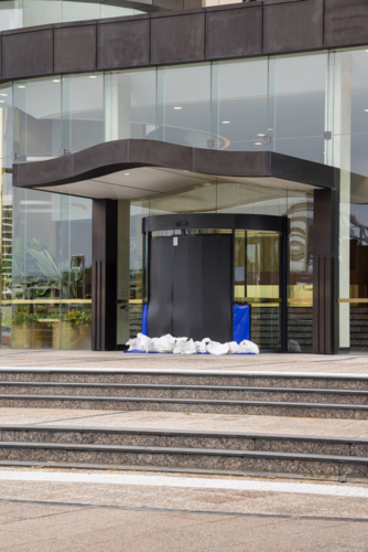 A building entrance is sandbagged and sealed in preparation for tropical cyclone Alfred in Brisbane - Australian Stock Image