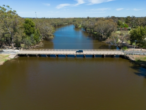 A car driving across a low bridge crossing of Lake Forbes - Australian Stock Image
