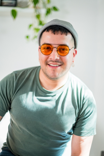 A cheerful man in his 30s poses in a casual setting, showcasing his vibrant personality and style - Australian Stock Image