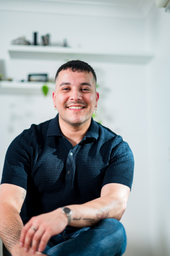 A cheerful man in his thirties poses casually indoors, showcasing a warm smile and relaxed vibe. - Australian Stock Image