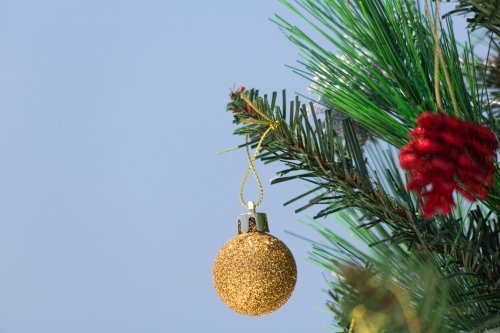 A Christmas tree is decorated with baubles.  A closeup with shallof dof and copy space.