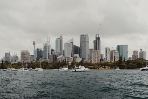 A cityscape of the Sydney on cloudy day with boats on the harbour. - Australian Stock Image