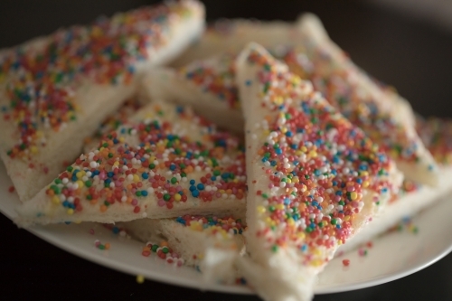 a Close up plate of fairy bread, bread buttered and then sprinkled with sprinkles