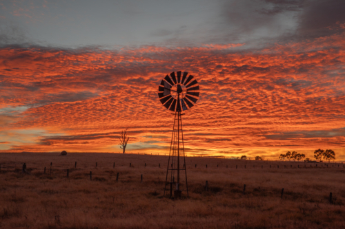 A colourful sunrise sky and a windmill - Australian Stock Image