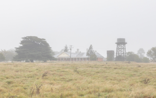 A country scene with an old homestead and a water tank - Australian Stock Image