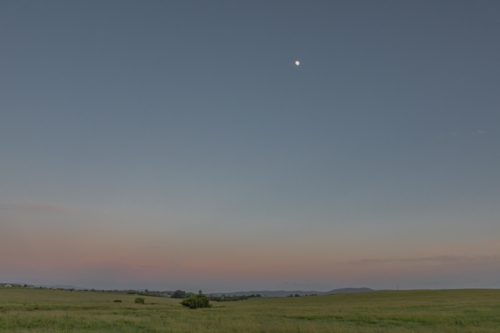 A dawn sky in the country under a setting full moon - Australian Stock Image