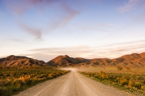 A dusty track leading to the Flinders Ranges at sunset - Australian Stock Image
