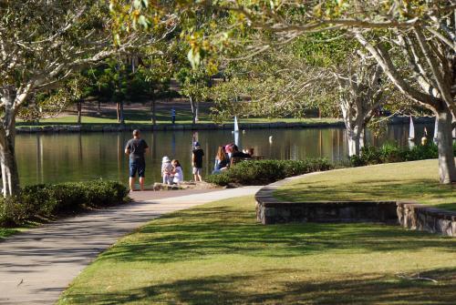 A Family down by the lake feeding ducks - Australian Stock Image