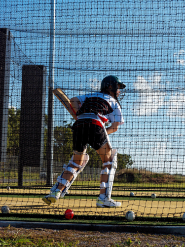 A female left handed cricket player batting in the nets - Australian Stock Image