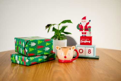 A festive Christmas scene with gifts, a reindeer mug, and a countdown calendar. - Australian Stock Image