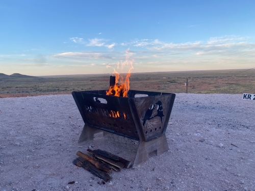 A fire pit made of metal with carvings in bare landscape - Australian Stock Image