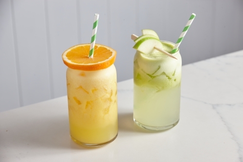 A glass of fresh orange juice and a glass of fresh apple juice. - Australian Stock Image