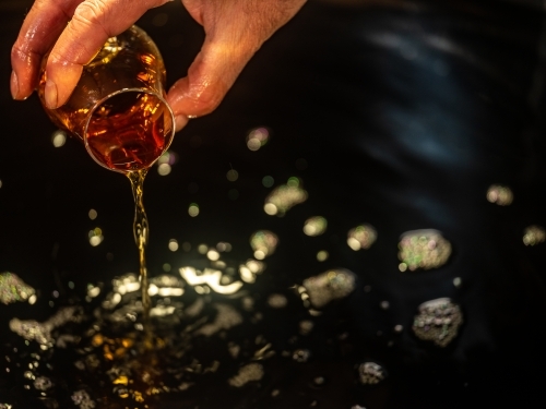 A glass of whisky poured into a whisky still - Australian Stock Image