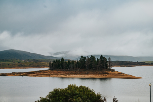a glassy lake during draught on a winter day during a cloudy and fog weather - Australian Stock Image