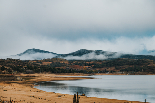 a glassy lake during draught on a winter day during a cloudy and fog weather - Australian Stock Image