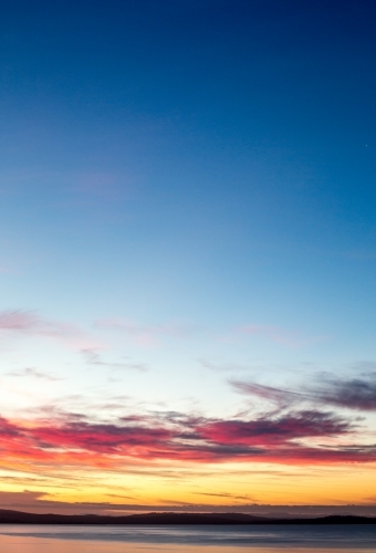 A golden sunset falls over the bay and distant peninsula - Australian Stock Image