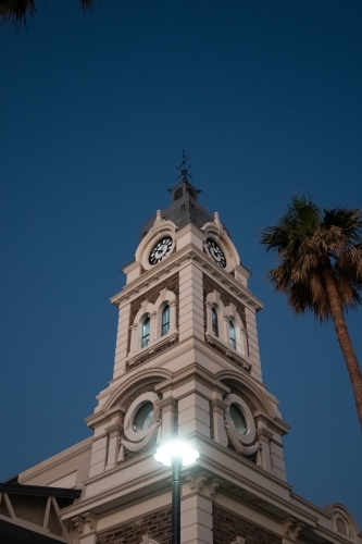 A grand prominent clock tower with palm trees on the sides - Australian Stock Image