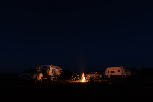 A group of people on a camping trip making a campfire - Australian Stock Image