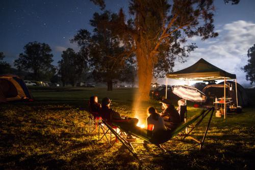 A group of people sitting around a campfire - Australian Stock Image