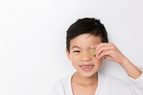 A happy young boy holding an australian coin - Australian Stock Image