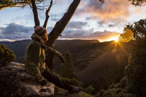 A hiker watching the sunset beside the Overland Track - Australian Stock Image