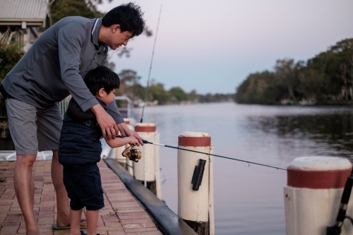 a kid being taught how to fish