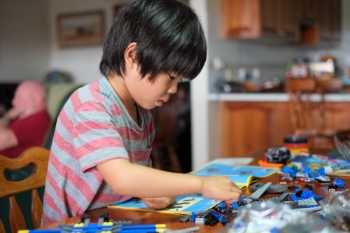 a kid building a Lego piece - Australian Stock Image
