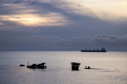 A large ship cruises through the waters of Moreton Bay with a moody sky behind. - Australian Stock Image