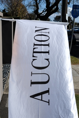 A large white flag advertising a property auction
