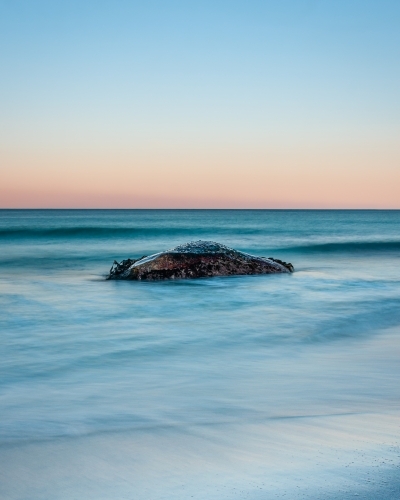 A Lone Rock Surrounded by a Pastel Sunset. - Australian Stock Image