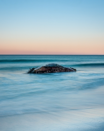 A Lone Rock Surrounded by a Pastel Sunset.