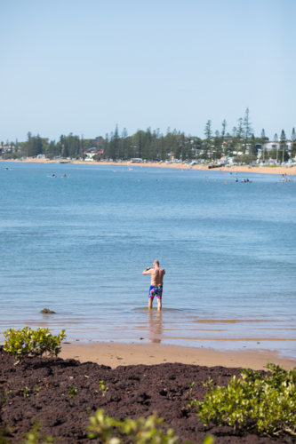 A male middle aged open water swimmer standing in water at Suttons Beach, Redcliffe - Australian Stock Image