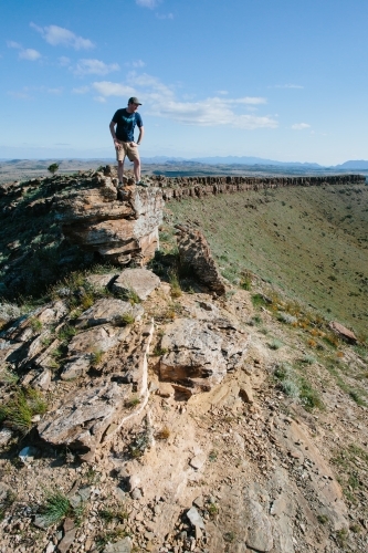 A man in hiking gear overlooking the rugged landscape of the Flinders Ranges - Australian Stock Image
