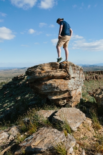 A man in hiking gear overlooking the rugged landscape of the Flinders Ranges - Australian Stock Image
