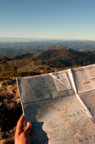 A map being held with mountain ranges in the background. - Australian Stock Image