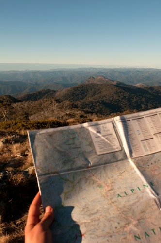 A map being held with mountain ranges in the background.