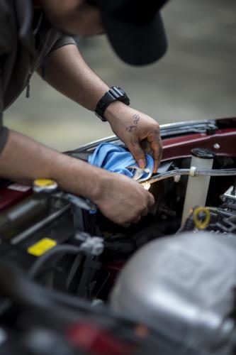 A mechanic inspects a headlight. - Australian Stock Image