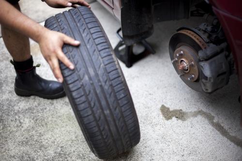 A mechanic inspects a tyre during a vehicle service.