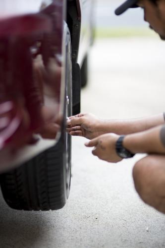 A mechanic inspects a tyre during a vehicle service.