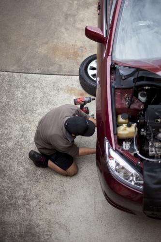 A mechanic services a vehicle.